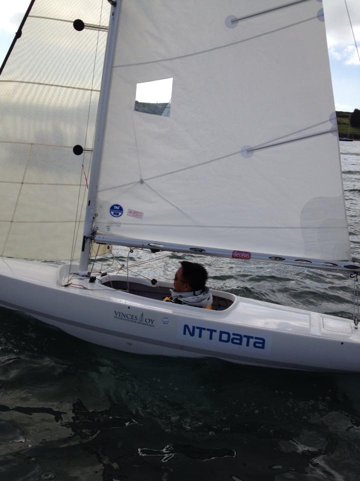 写真：NTTDATAロゴ入りの小型ヨットに乗った山本真也がセーリングしている様子